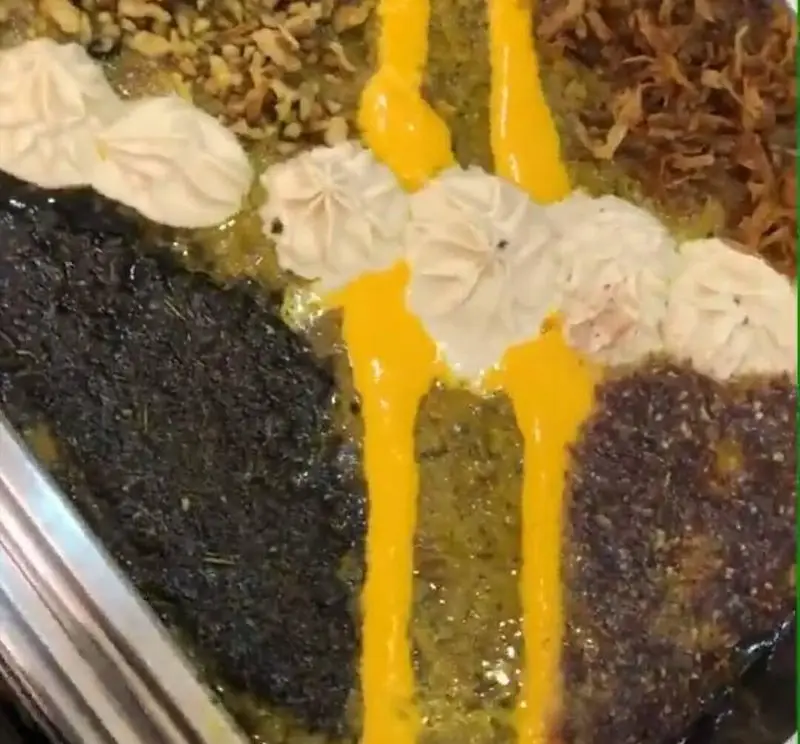 سفره رنگین و متنوع غذاهای سنتی ایرانی در رستوران سپیدار با تزیین هنرمندانه زعفران، پیاز داغ و کشک، یک تجربه اصیل غذایی.