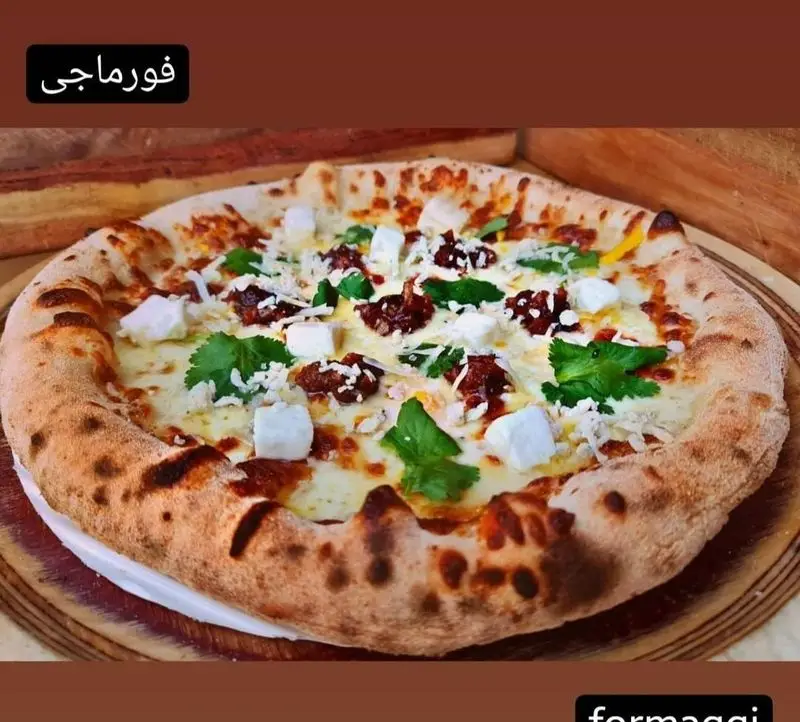 پیتزا فورماجی خوش‌رنگ و خوش‌طعم کوچینا پیتزا، با پنیر فراوان (مکعبی و رنده شده)، گوجه خشک و سبزیجات تازه معطر، آماده سرو.