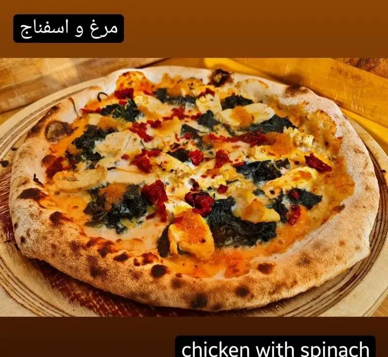 پیتزا مرغ و اسفناج خوش‌طعم کوچینا پیتزا، پخته شده با تکه‌های مرغ تازه، اسفناج مرغوب، پنیر موزارلا و خمیر ترد برای یک تجربه غذایی عالی.