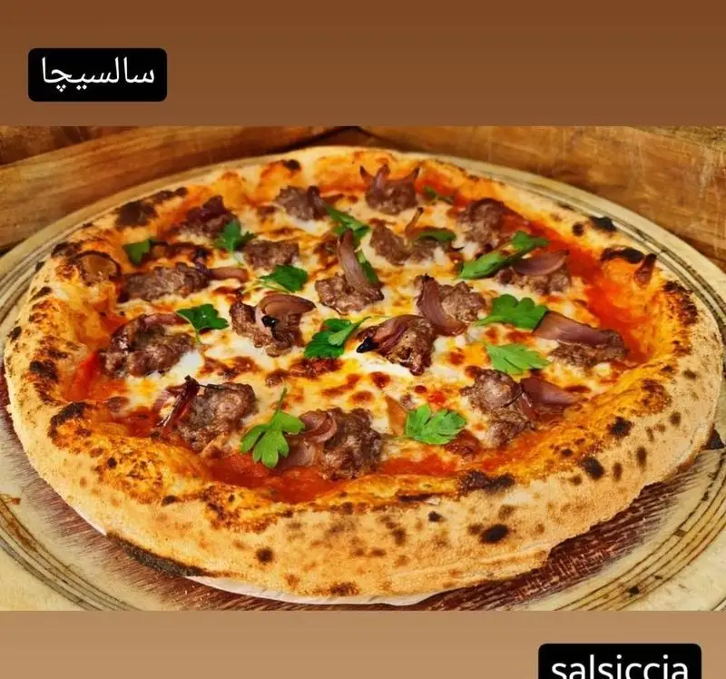 پیتزا سالسیسیا خوشمزه کوچینا پیتزا با سوسیس تازه، پنیر موزارلا و پیاز کاراملی. ایده‌آل برای دوستداران غذای ایتالیایی.
