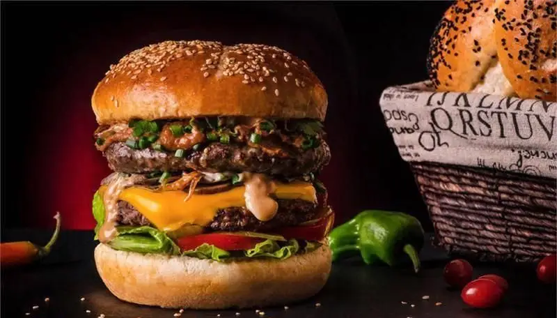 همبرگر چند طبقه و ویژه برگر ۱۳۵۸ با نان کنجدی، گوشت دست‌ساز، پنیر آب شده و سبزیجات تازه و اشتهاآور.
