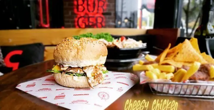 برگر مرغ پنیری خوشمزه با نان کنجدی، به همراه سیب زمینی سرخ کرده و ناچوز در محیط دلنشین رستوران برگر ۱۳۵۸.
