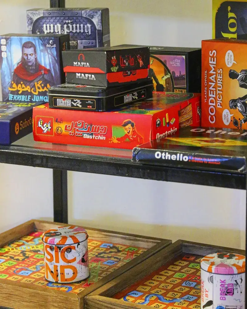 بازی‌های فکری متنوع از جمله مافیا، کدنامز، دستچین و سابوتور روی قفسه‌های کافه بینج، انتخابی عالی برای علاقه‌مندان به بردگیم و سرگرمی.
