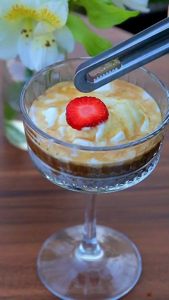 دسر قهوه سرد و مجلل کافه بینج: ترکیبی از بستنی وانیلی، سس کارامل غلیظ، توت فرنگی تازه و تزئین خاص. لذت در کافه بینج.