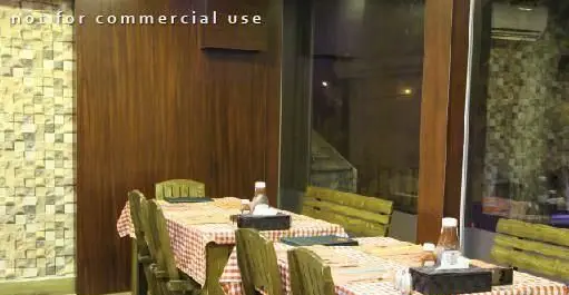 فضای داخلی رستوران بان کو با میزهای چوبی، رومیزی شطرنجی قرمز و سفید، دکوراسیون گرم و محیطی دنج برای سرو غذا.