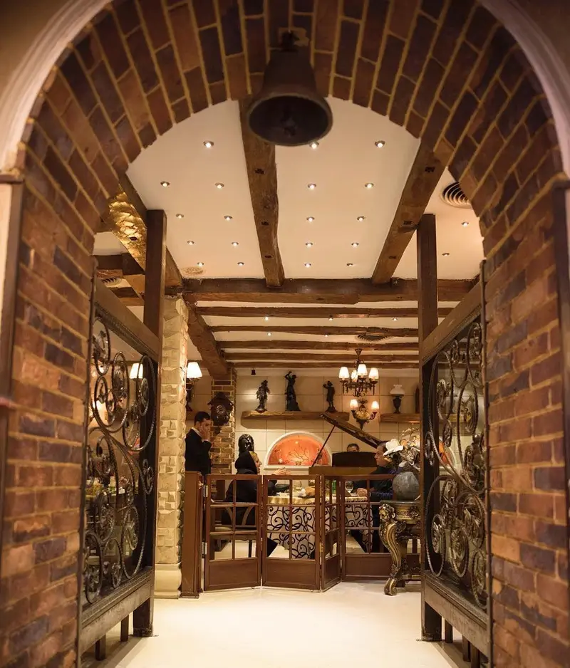 تصویری از ورودی زیبای رستوران نایب وزرا با آجرکاری سنتی، سقف چوبی و دکوراسیون گرم و دلنشین، فضایی ایده آل برای میهمانی‌ها.