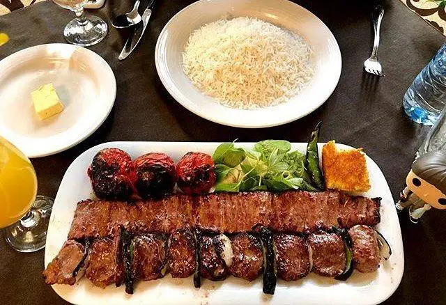 چلوکباب لذیذ و متنوع رستوران نایب وزرا، شامل کباب برگ و کوبیده با برنج ایرانی، گوجه کبابی و سبزی تازه. غذای اصیل ایرانی.