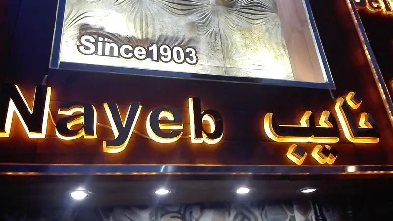 تابلوی نورانی و لوکس رستوران نایب وزرا با حروف برجسته طلایی و عبارت "Since 1903"، نشان دهنده قدمت و اصالت یک مجموعه غذایی.