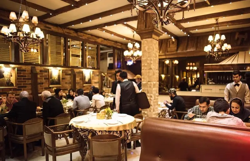 نمای داخلی رستوران نایب وزرا با دکوراسیون لوکس و چوبی، محیطی گرم و دلنشین برای صرف غذا و تجربه عالی مشتریان در فضایی سنتی.