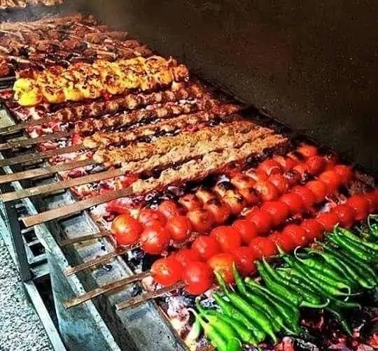 کباب و جوجه کباب اصیل ایرانی به همراه گوجه و فلفل تازه کبابی بر روی منقل داغ در سفره خانه سنتی بی بی گل. طعم بی‌نظیر و کیفیت عالی.