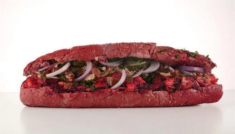 ساندویچ ساب بزرگ و جذاب با نان قرمز منحصر به فرد و مخلفات وسوسه‌انگیز مرغ طعم‌دار، پیاز و سبزیجات تازه از بستنی ایوب