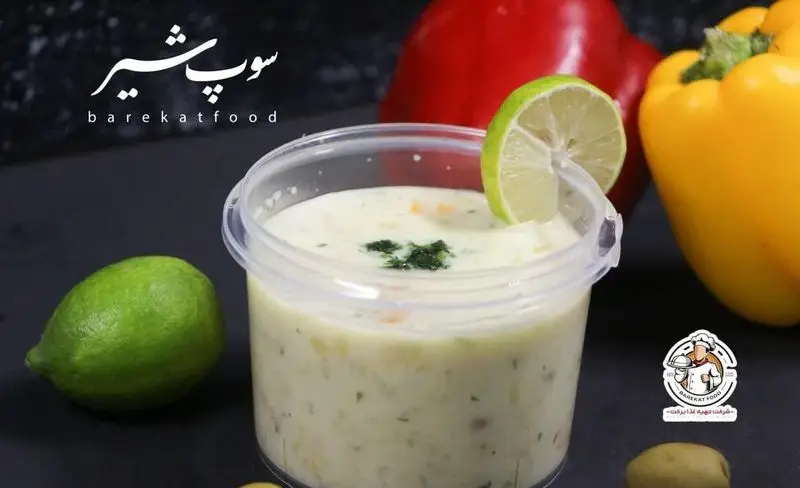 تصویری از سوپ شیر غلیظ و خوشمزه شرکت تهیه غذا برکت در ظرف شفاف با لیموی تازه، انتخابی سالم و مقوی از کترینگ برکت.