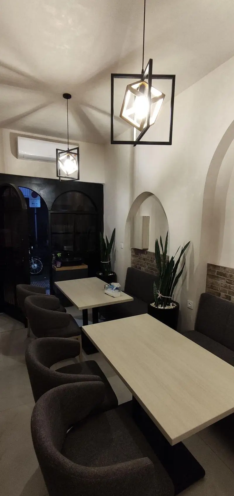 فضای داخلی جذاب رستوران سید جلال با دکوراسیون مدرن و تلفیقی، میزهای چوبی و صندلی‌های راحت، نورپردازی خاص و گیاهان زینتی.