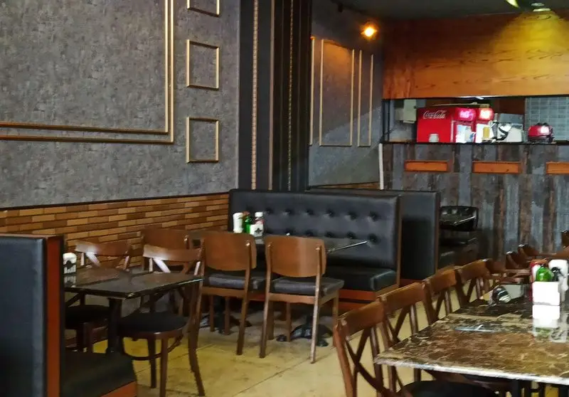 تصویری از محیط داخلی فست فود گزینگ برگر، با طراحی مدرن و نیمکت‌های راحتی که فضای دلنشینی برای غذا ارائه می‌دهد.