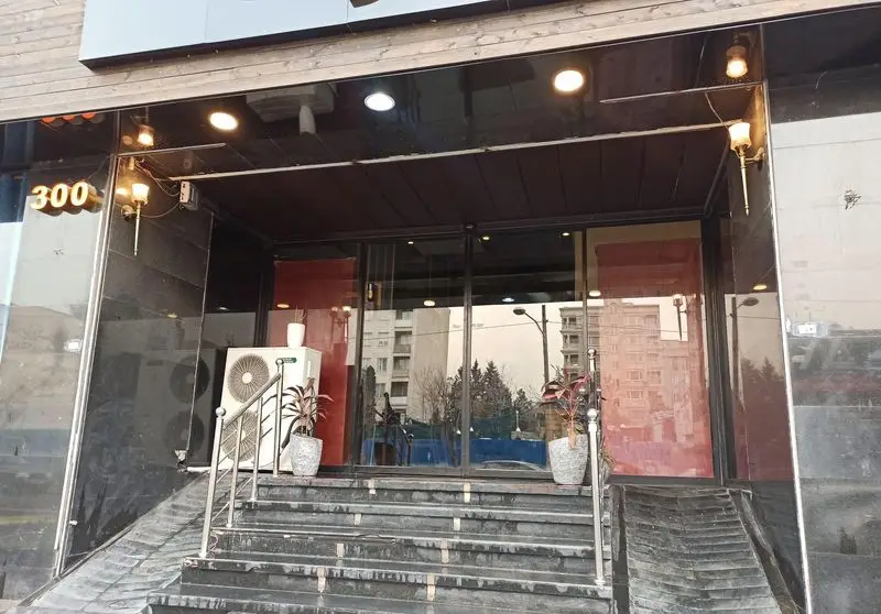 ورودی فست فود گزینگ برگر شماره ۳۰۰ با پله‌ها و درب شیشه‌ای، نمای مدرن و دعوت‌کننده برای بهترین برگر و غذاهای فست فود.