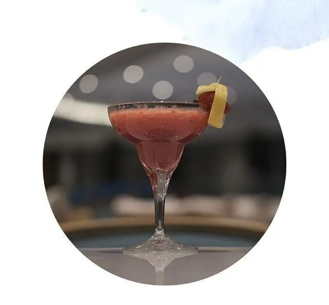 کوکتل میوه ای خنک و خوشرنگ کافه لوما در لیوان مارگاریتا، تزئین شده با لیمو و توت، ایده‌آل برای روزهای گرم و لحظات شاد.