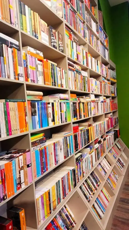 نمایی از قفسه‌های پر از کتاب در فروشگاه کتاب داربوک. تنوع بالای کتاب‌ها از رمان و ادبیات تا علمی در فضایی دلنشین برای خرید و مطالعه.