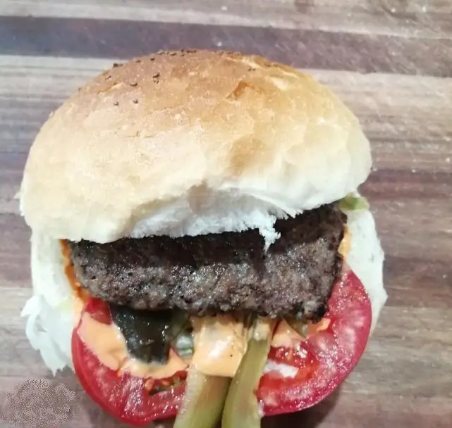 برگر گوشت آبدار و خوشمزه از پیتزا اروند، آماده سرو با نان تازه، گوجه، خیارشور و سس مخصوص. انتخابی عالی برای دوستداران فست فود.