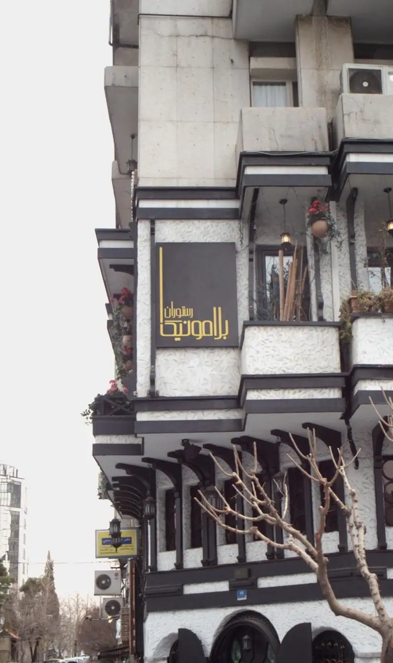 ورودی و نمای زیبای رستوران ایتالیایی بلامونیکا، با معماری چشم‌نواز، گلدان‌های آویزان و تابلوی برند رستوران در روز روشن