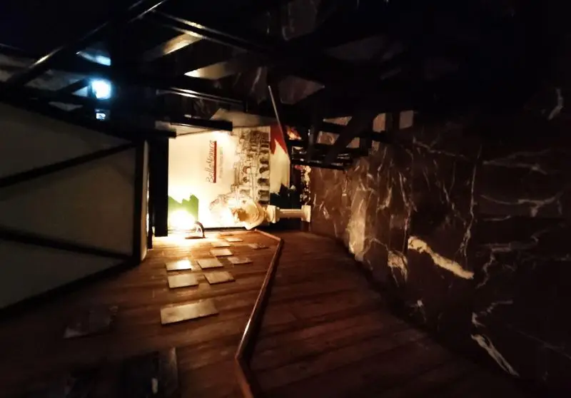 دکوراسیون داخلی چشم‌نواز رستوران ایتالیایی بلامونیکا با کفپوش چوبی، دیوار مرمری، و تابلوهای هنری، فضایی دنج و خاطره‌انگیز.