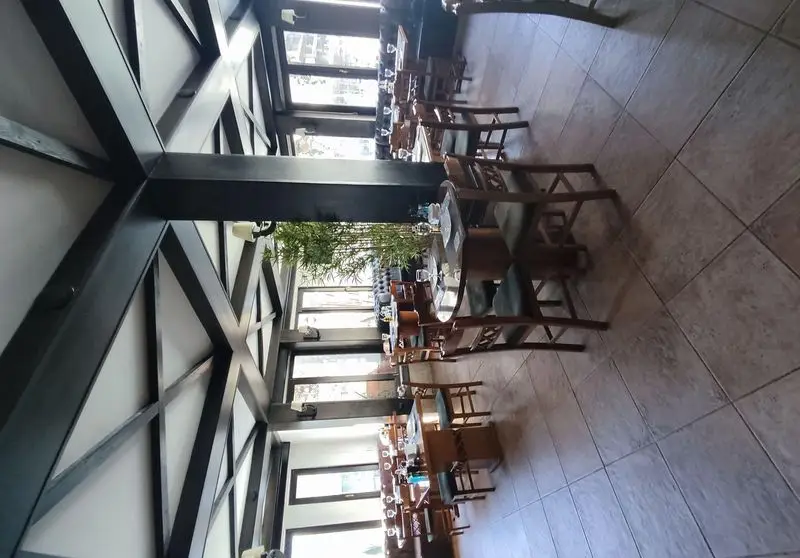 دکوراسیون داخلی لوکس رستوران ایتالیایی بلامونیکا؛ با سقف چوبی خاص، میز و صندلی‌های چیده شده و پنجره‌های بزرگ برای فضایی دلنشین.