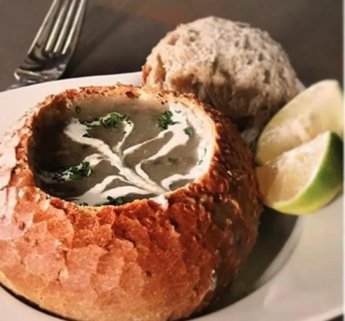 سوپ مخصوص بلامونیکا، خامه ای و داغ، سرو شده در کاسه نان برشته با لیمو. غذایی ایده‌آل در رستوران ایتالیایی بلامونیکا.