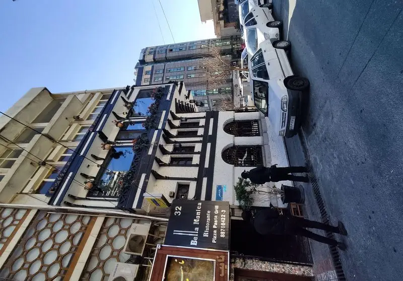 نمای بیرونی رستوران ایتالیایی بلامونیکا با طراحی سیاه و سفید، پیتزا، پاستا و گریل. یک مکان دنج و شیک در تهران.