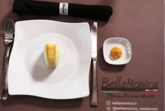 نمای میز سرو در رستوران ایتالیایی بلامونیکا: بشقاب با نان تازه و سس مخصوص، آماده شروع یک تجربه غذایی لذت‌بخش و خاطره‌انگیز.