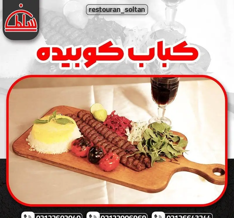 کباب کوبیده رستوران سلطان، سرو شده با برنج زعفرانی، گوجه کبابی، لیمو، سبزی تازه و سالاد کلم قرمز. غذای اصیل ایرانی.