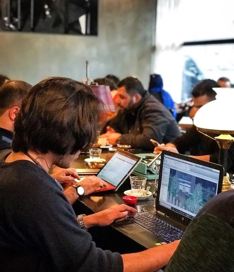 تصویری از کافه تایپ، فضایی مناسب کار و مطالعه. مشتریان در حال استفاده از لپ‌تاپ‌های خود، نوشیدن قهوه و تمرکز بر فعالیت‌های کاری یا دانشجویی.