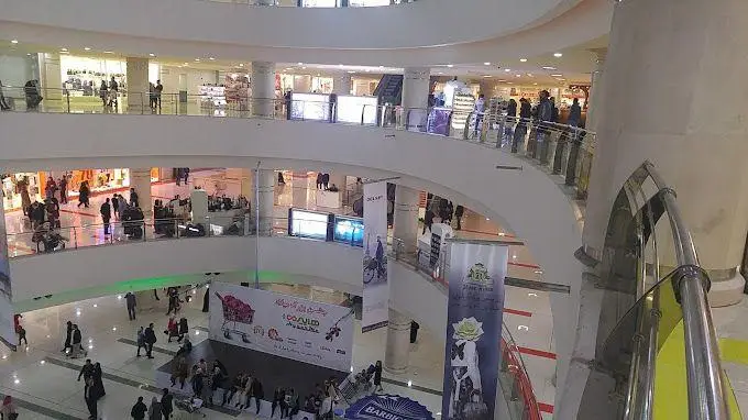 نمایی گسترده از فضای داخلی مگا مال، مرکز خرید بزرگ و چند طبقه با حضور پرشور مشتریان و فروشگاه‌های متنوع برای تجربه‌ای جذاب از خرید.