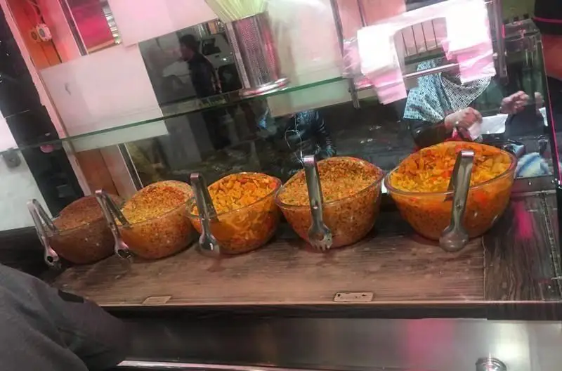 نمای کانتر ساندویچی فلافل مامان جون با کاسه‌های پر از مخلفات و سالادهای تازه برای تهیه فلافل‌های اصیل و خوش طعم.