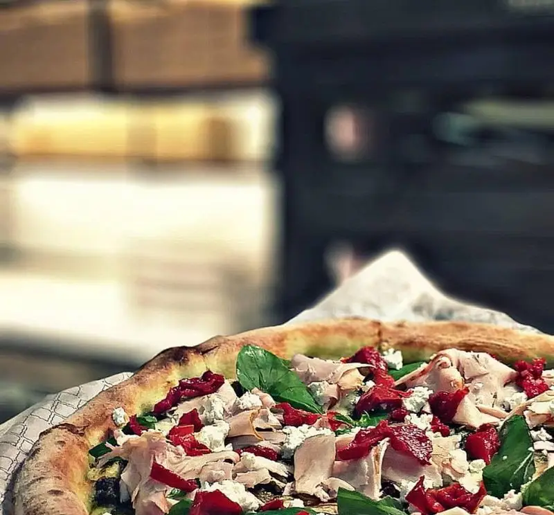 پیتزا ایتالیایی تازه با خمیر پفکی، پنیر فتا، گوجه خشک، گوشت رول‌شده و سبزیجات معطر از منوی رستوران بونو ظفر در ظفر.