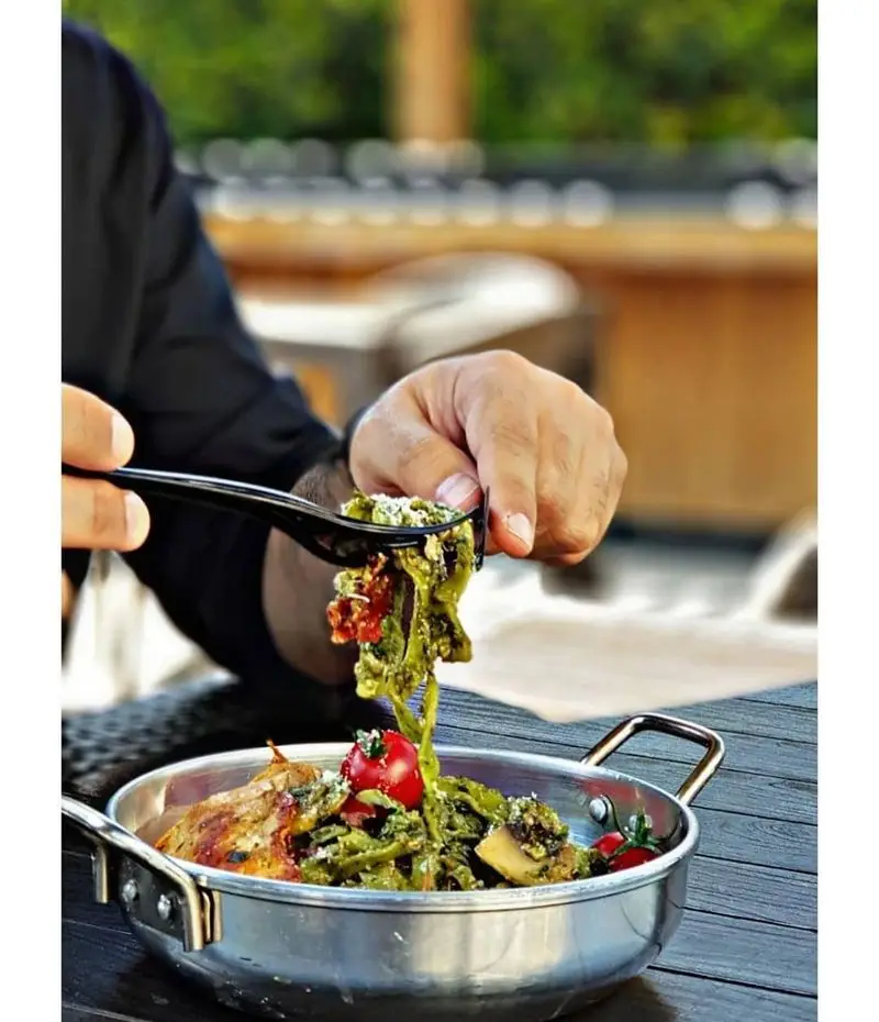 پاستای سبز مخصوص با گوجه گیلاسی و مرغ گریل، سرو شده در رستوران ایتالیایی بونو ظفر. لذت یک غذای خوشمزه ایتالیایی در تهران.