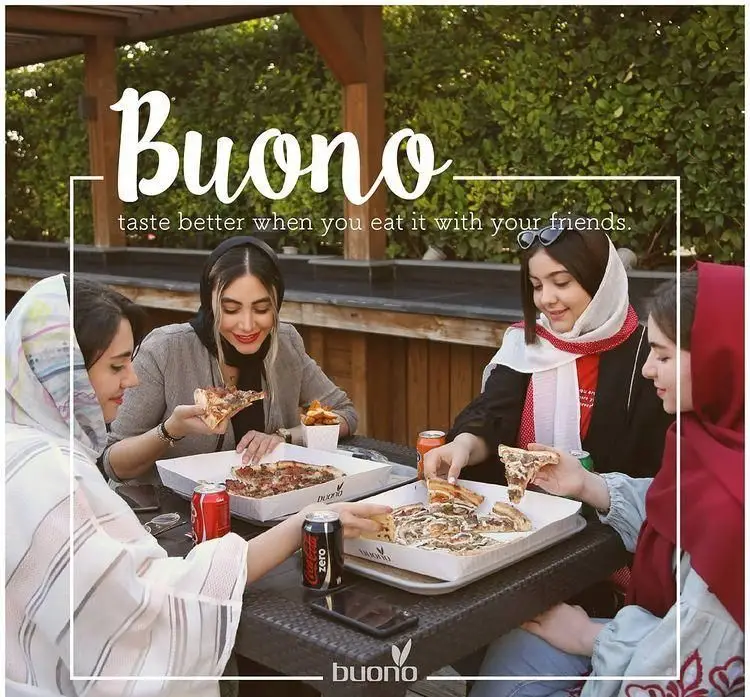 لحظات شاد دوستان در فضای باز رستوران ایتالیایی بونو ظفر؛ دختران جوان مشغول خوردن پیتزاهای لذیذ و نوشیدنی.