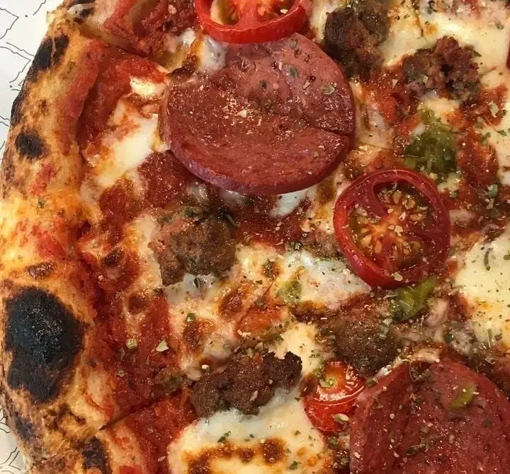 پیتزا ایتالیایی خوشمزه بونو ظفر با کراست ترد، پپرونی، گوشت چرخ کرده، گوجه فرنگی، سس مارینارا و پنیر موزارلا. غذای لذیذ در رستوران ایتالیایی بونو.