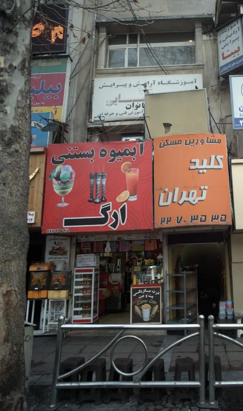 نمایی از خیابان با مغازه آبمیوه بستنی ارگ و تابلوی قرمز بزرگ آن، نمایش بستنی، انواع آبمیوه‌های تازه و نوشیدنی‌های خنک