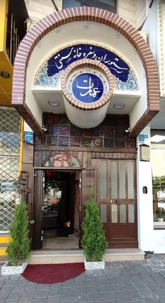 تصویر نمای بیرونی و ورودی رستوران سنتی و سفره خانه عمارت، با سردر آجری زیبا، کاشی‌کاری سنتی آبی و درب‌های چوبی کلاسیک