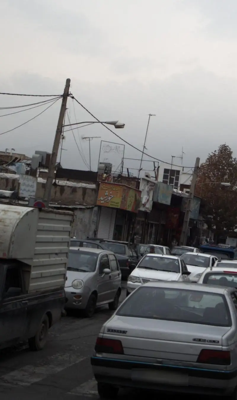 نمایی شلوغ از خیابان شهری با تابلو "تهیه غذا و فست فود خورشید" و شماره تلفن ۲۲۶۸۲۴۹۹، منعکس‌کننده فعالیت پر جنب و جوش این مجموعه.
