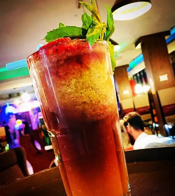 تصویری جذاب از نوشیدنی خنک و لایه‌لایه میوه‌ای با توت فرنگی، نعناع و رنگ‌های زنده، انتخابی ایده‌آل برای مشتریان کافه رستوران سالار در فصل تابستان.