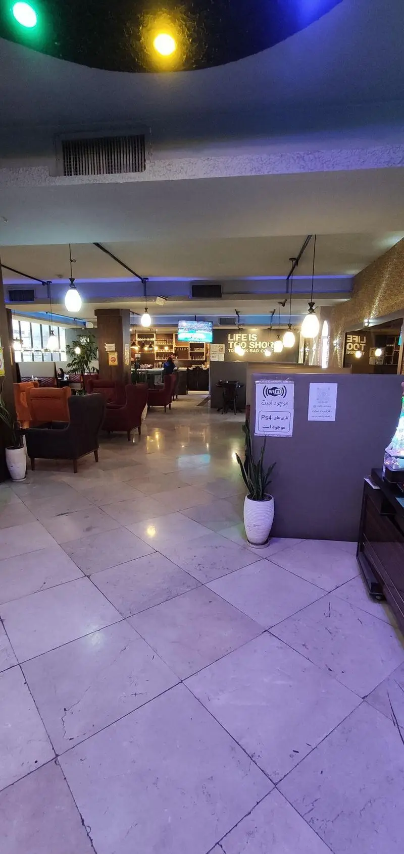 تصویری از فضای داخلی دلنشین کافه رستوران سالار با صندلی‌های راحت، میزها، نورپردازی زیبا، وای فای و بازی PS4.