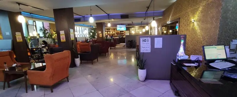 فضای داخلی کافه رستوران سالار با دکوراسیون مدرن، مبلمان راحت نارنجی و قرمز، نورپردازی دلنشین و محیطی آرام برای پذیرایی مهمانان.