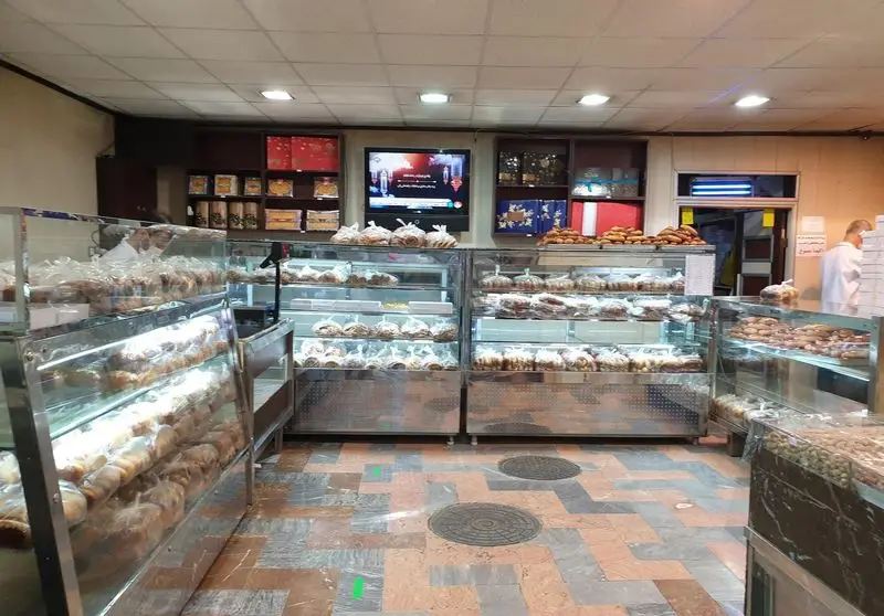 فضای داخلی قنادی فرح بخش با ویترین های شیشه ای و استیل، مملو از انواع شیرینی های تازه و بسته بندی شده در محیطی مرتب و بهداشتی.