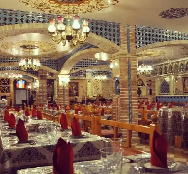 محیط داخلی سفره خانه سنتی باربد با دکوراسیون سنتی ایرانی، سقف‌های طرح‌دار، آجرکاری و کاشی‌کاری زیبا و میز و صندلی چوبی.