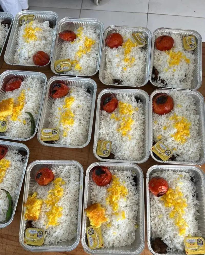 بسته بندی شیک و بهداشتی چلو کباب و غذای ایرانی تهیه غذای ستاره ایلیا، شامل برنج زعفرانی، گوجه کبابی و ته دیگ، آماده برای شرکت ها و مراسم.