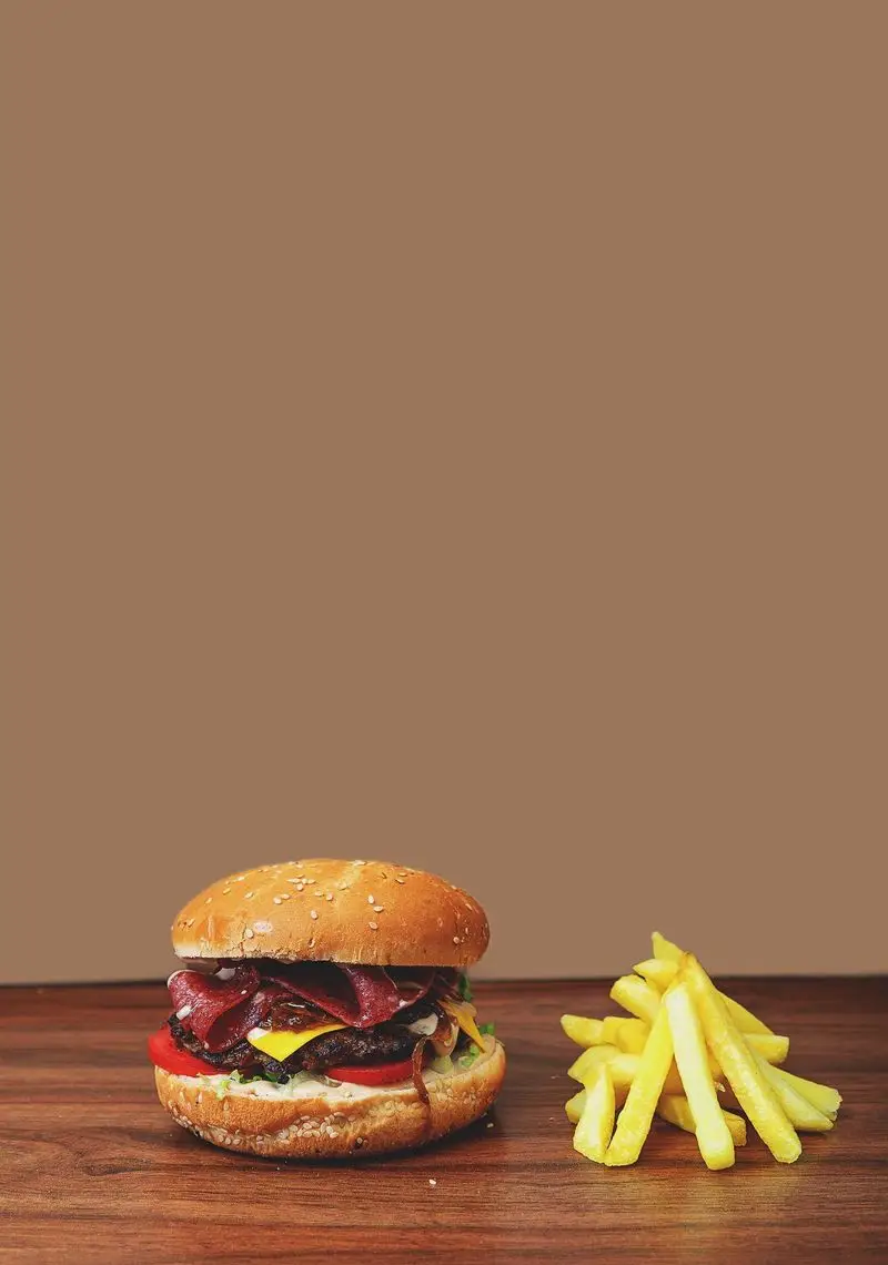 برگر لذیذ با پنیر، گوجه، کاهو و بیکن در کنار سیب زمینی سرخ کرده تازه. پیتزا آمی چی، بهترین انتخاب برای فست فود.