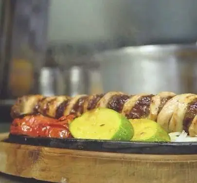 بشقاب داغ کباب مخصوص و سبزیجات کبابی تازه در کافه رستوران زیرزمین، انتخابی ایده‌آل برای یک وعده ناهار یا شام لذیذ.