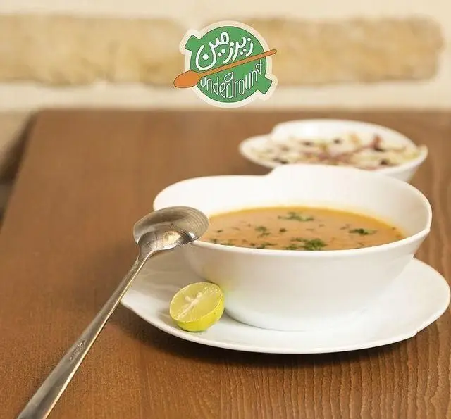 سوپ عدس داغ و لذیذ با چاشنی لیمو در کافه رستوران زیرزمین، انتخابی عالی برای یک وعده غذای سالم و مقوی در فضایی دلنشین.
