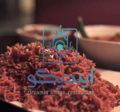 یک بشقاب برنج قرمز خوش‌رنگ و لذیذ، غذای اصلی و محبوب کافه رستوران زیرزمین ایندیگو، آماده سرو برای میهمانان عزیز.