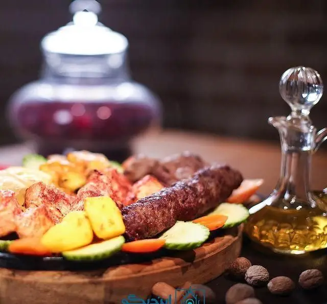 سینی جذاب کباب کوبیده و جوجه کباب با سبزیجات تازه در کافه رستوران زیرزمین، انتخابی ایده‌آل برای ناهار و شام.